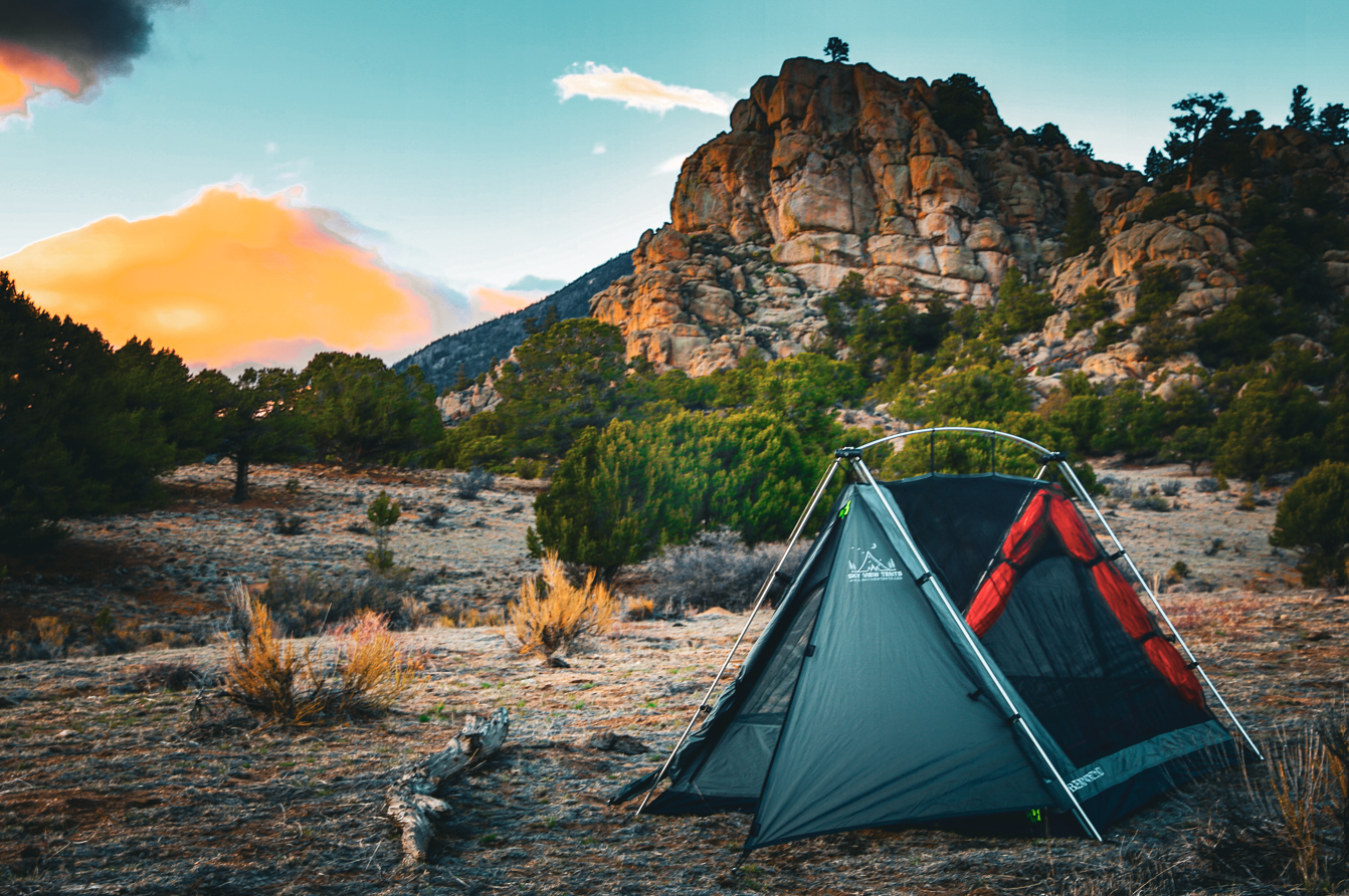 Sky View Duo Tent teal with red mesh panels pitched on a desert campsite by rugged hills on Tampa Home & Garden Store