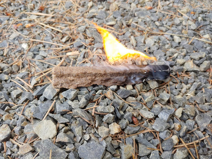 Fire Starter River Country Gear, brown fibrous block burning on gravel on Tampa Home & Garden Store