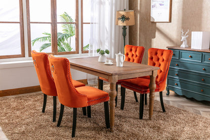 Tufted velvet orange dining chairs set of four with nailhead trim and black legs around a wood table on Tampa Home & Garden Store