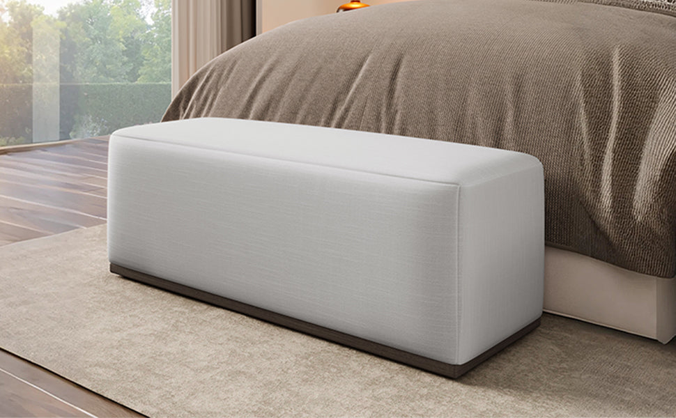 HouseOfZazla footstool bench in light gray fabric with dark wood base beside bed on Tampa Home & Garden Store