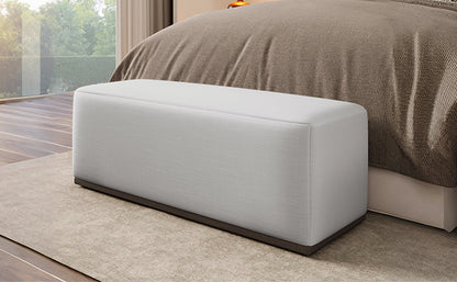 HouseOfZazla footstool bench in light gray fabric with dark wood base beside bed on Tampa Home & Garden Store