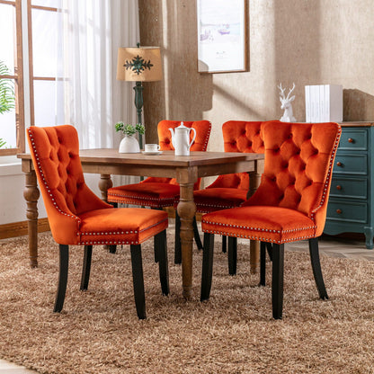 Tufted dining chair set in orange velvet with nailhead trim around a wooden dining table on Tampa Home & Garden Store