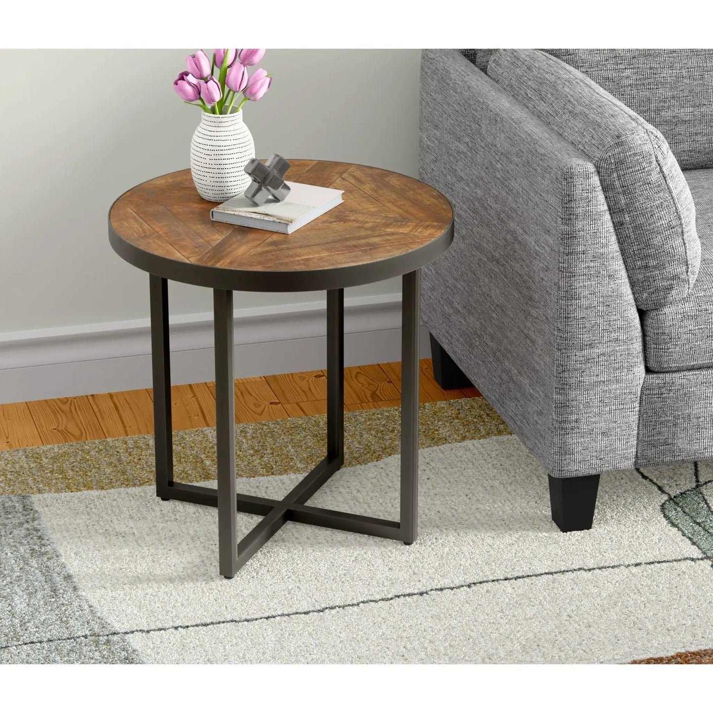 Faro Round Table wood top with dark metal base; tulip vase, books, and gray decor beside sofa on Tampa Home & Garden Store
