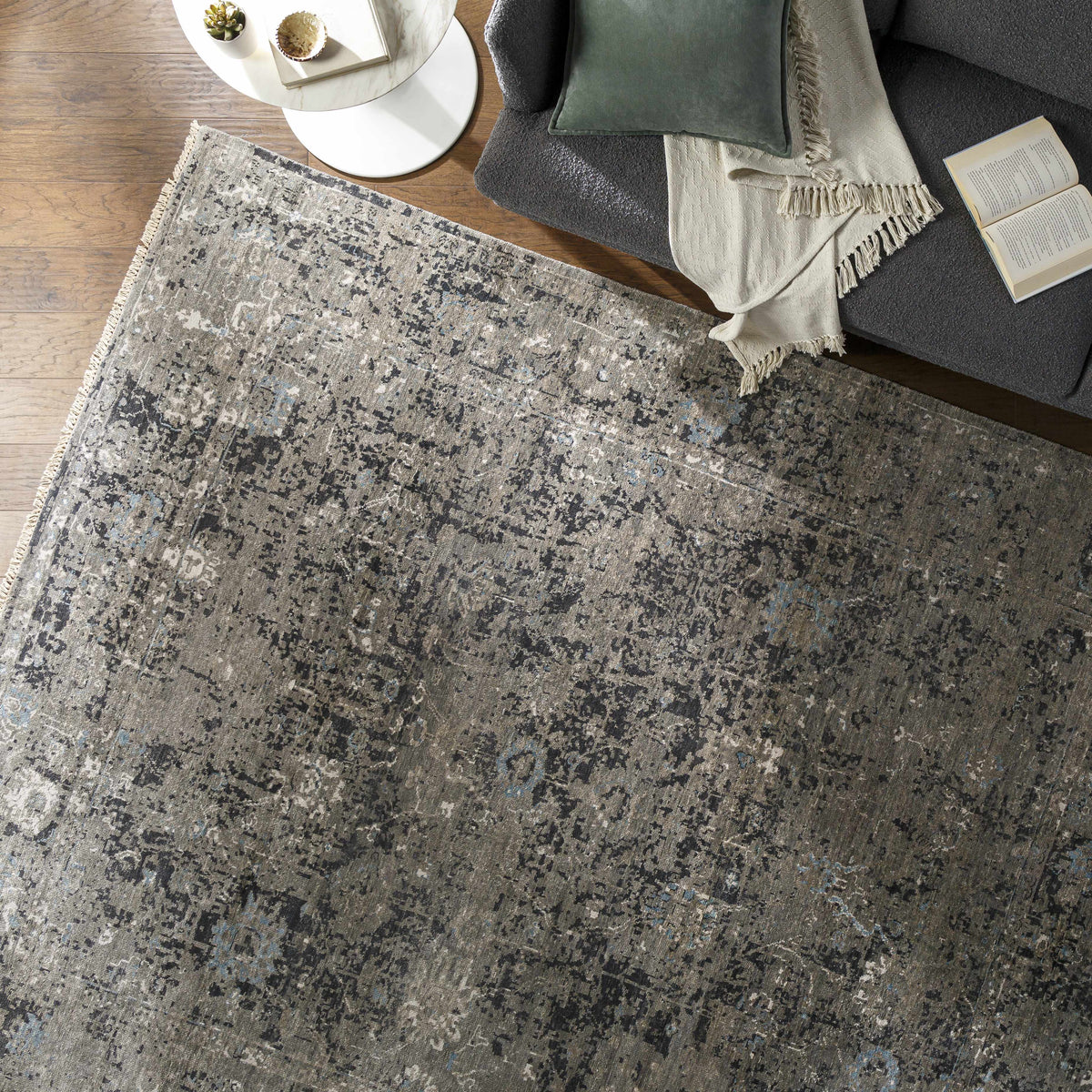 Becerril Premium Rug gray-blue tones with a fringe border in a living room setting on Tampa Home & Garden Store