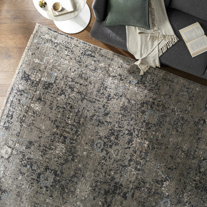 Becerril Premium Rug gray-blue tones with a fringe border in a living room setting on Tampa Home & Garden Store