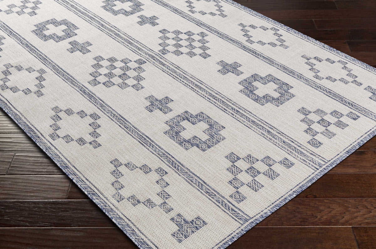 Besao indoor outdoor rug by Boutique Rugs; blue geometric motifs on cream background on Tampa Home & Garden Store