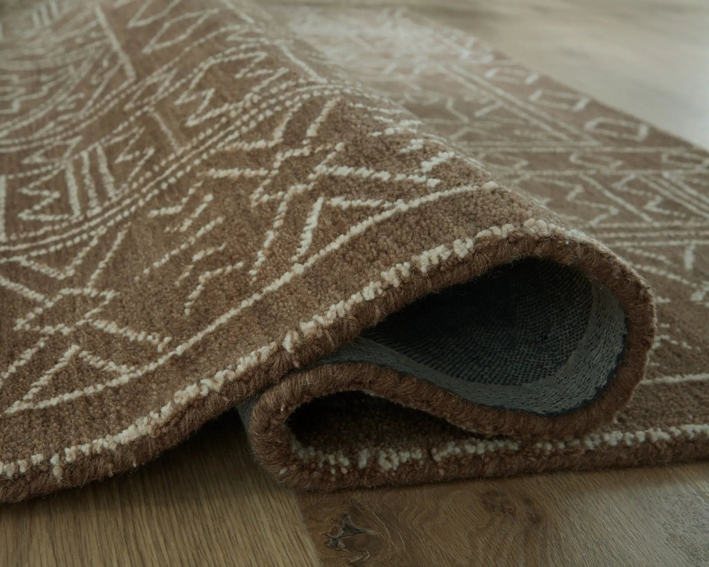 Merrittman Rug brown geometric area rug by Unique Piece Furniture folded to show underside on Tampa Home & Garden Store