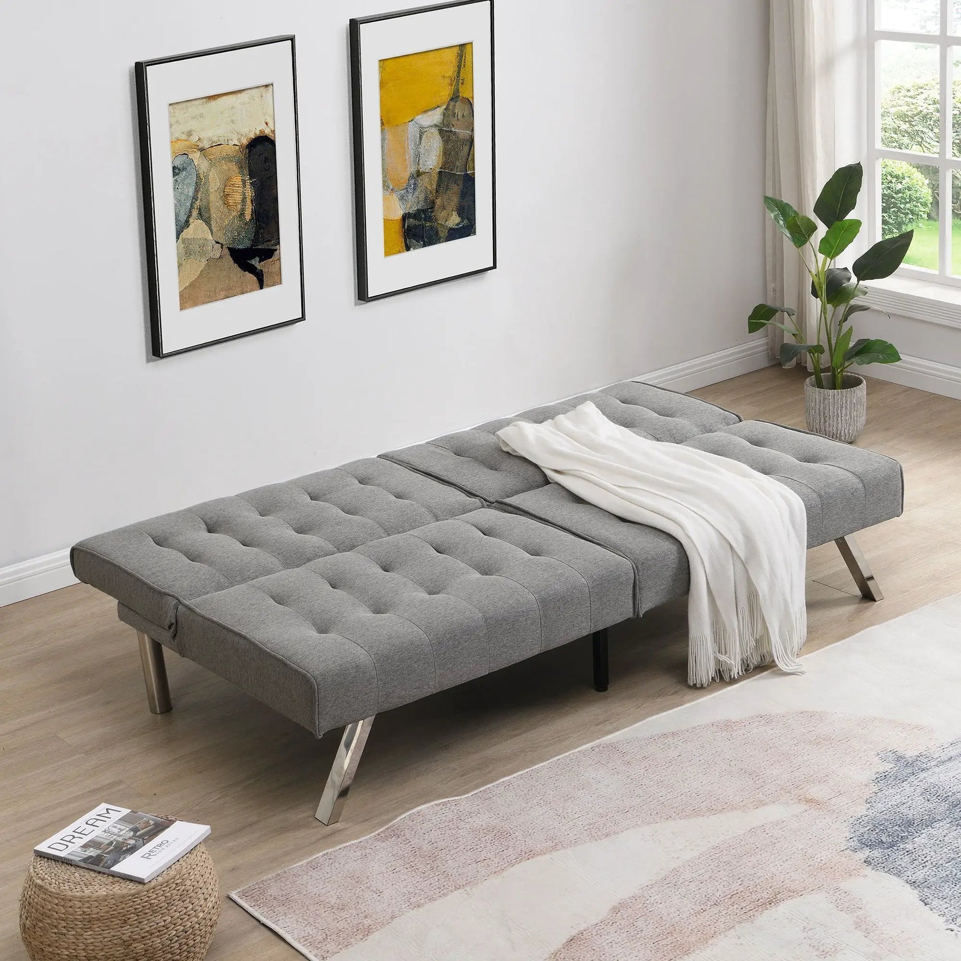 Two gray tufted Futon Sofas with metal legs by Unique Piece Furniture in a bright bedroom on Tampa Home & Garden Store