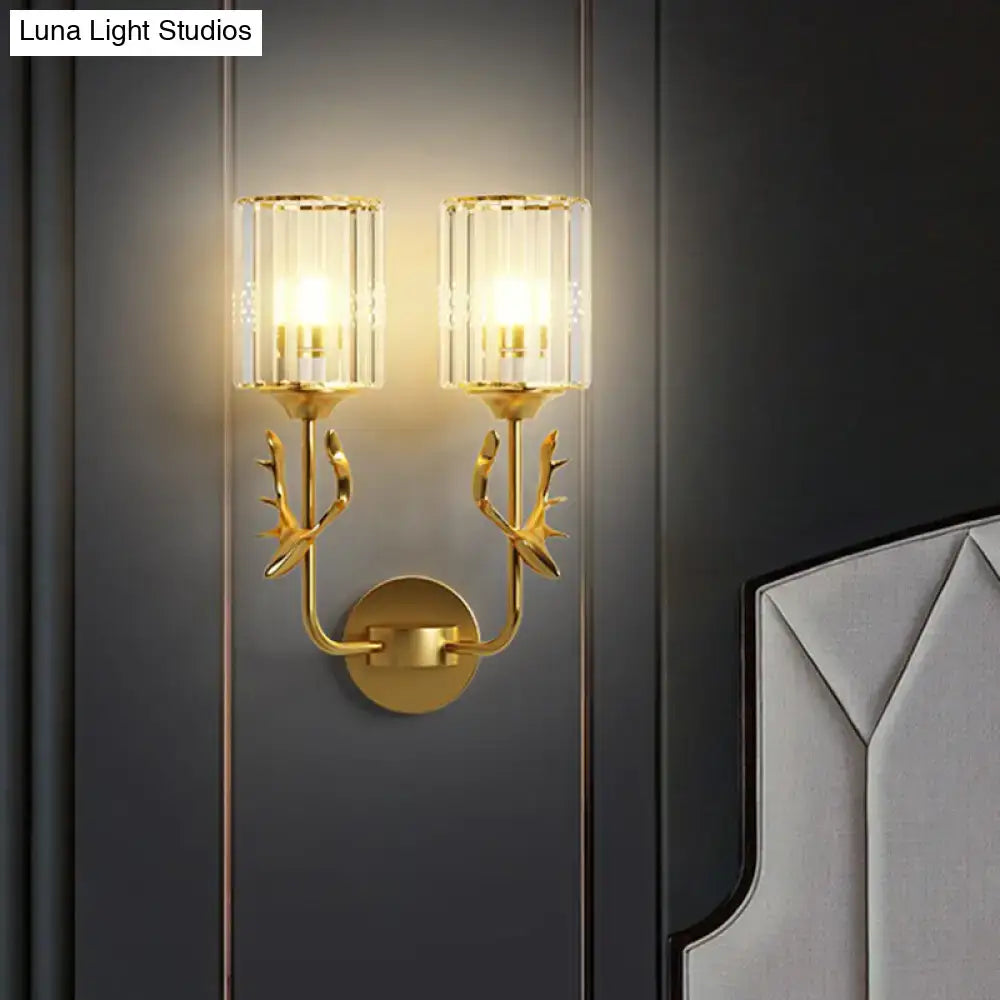 Black Antler Crystal Sconce with twin glass cylinder shades and gold-tone antlers on dark wall on Tampa Home & Garden Store