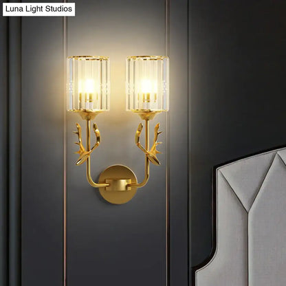 Black Antler Crystal Sconce with twin glass cylinder shades and gold-tone antlers on dark wall on Tampa Home & Garden Store