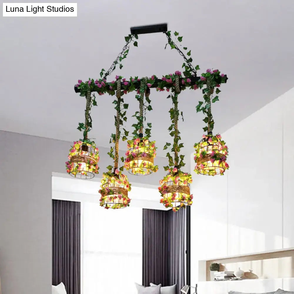 Black industrial chandelier by Decorbites with five ivy-wrapped cage pendants and pink flowers on Tampa Home & Garden Store