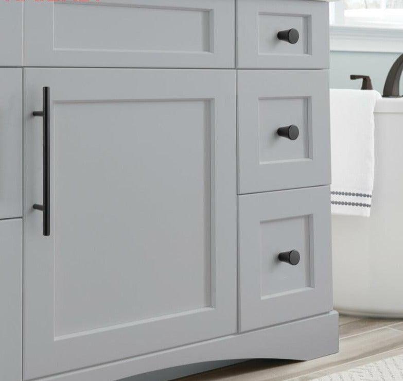 Cabinet knob and pull set in black stainless steel with three round knobs and a vertical bar handle on gray cabinet on Tampa Home & Garden Store