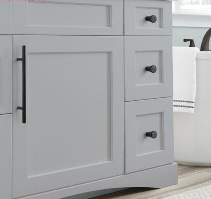Cabinet knob and pull set in black stainless steel with three round knobs and a vertical bar handle on gray cabinet on Tampa Home & Garden Store