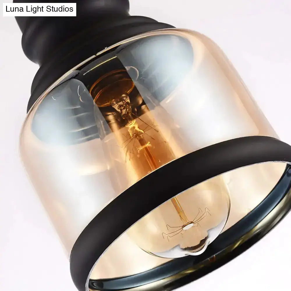 Industrial black cylinder pendant light with a clear glass shade and exposed filament bulb on Tampa Home & Garden Store