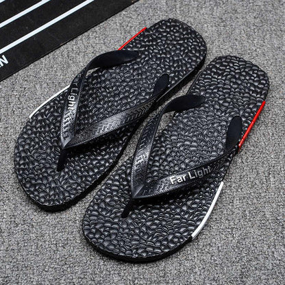 Two black men's flip flop sandals with textured footbeds and Far Light branding on straps on Tampa Home & Garden Store