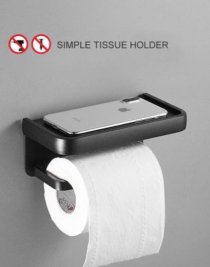 Stevvex matte black toilet paper holder with shelf and adhesive mount, phone resting on top on Tampa Home & Garden Store