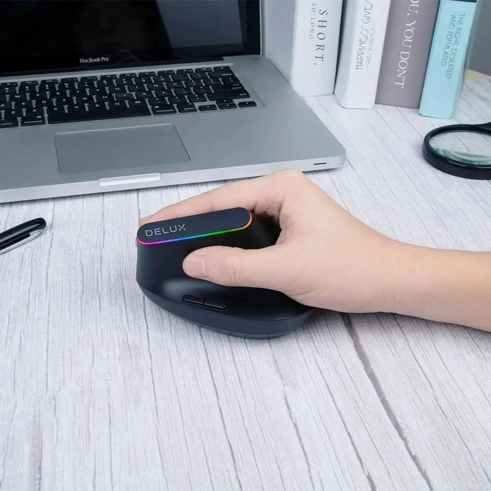 Delux black wireless ergonomic vertical mouse with RGB, 1600 DPI, USB receiver beside laptop on Tampa Home & Garden Store