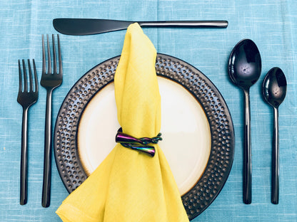 Vibhsa Black 20-Piece Stainless Steel Flatware Set on blue table with yellow napkin and plate on Tampa Home & Garden Store