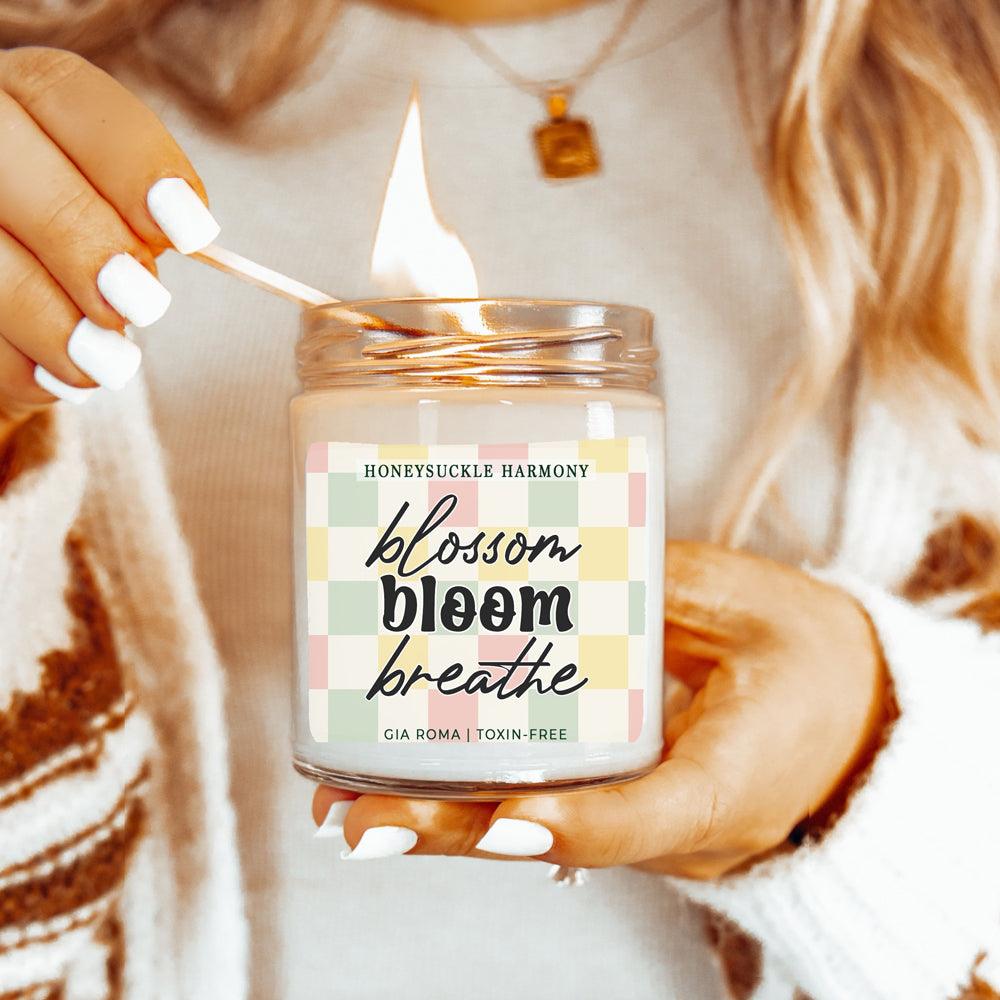 Honeysuckle Harmony Candle Gia Roma in clear jar with pastel check label, lit by a match on Tampa Home & Garden Store