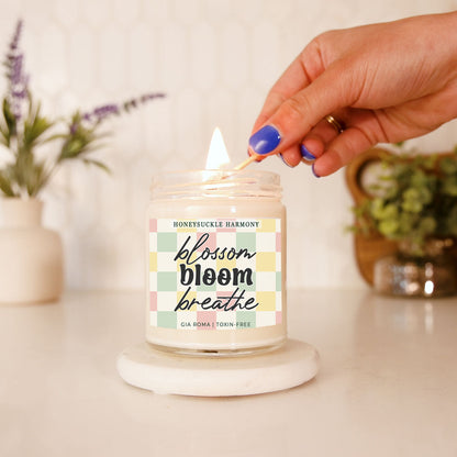 Honeysuckle Harmony candle by Gia Roma in a glass jar with pastel label lit by blue nails on Tampa Home & Garden Store