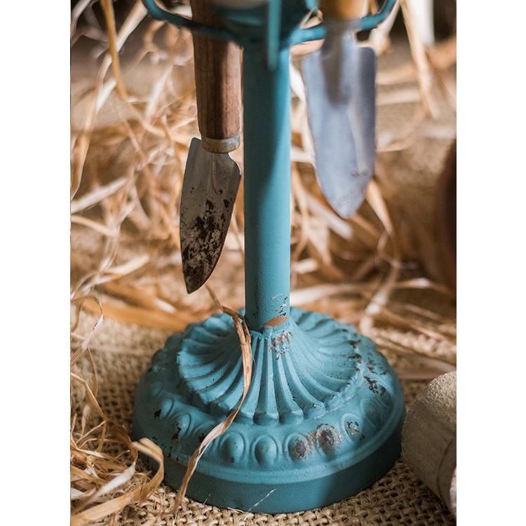 Blue cup holder planter stand with two hanging garden trowels on Tampa Home & Garden Store