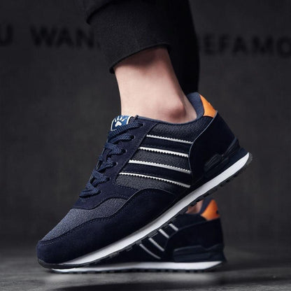 Blue men's casual sneakers with navy mesh, suede overlays, white stripes, orange heel tab on Tampa Home & Garden Store