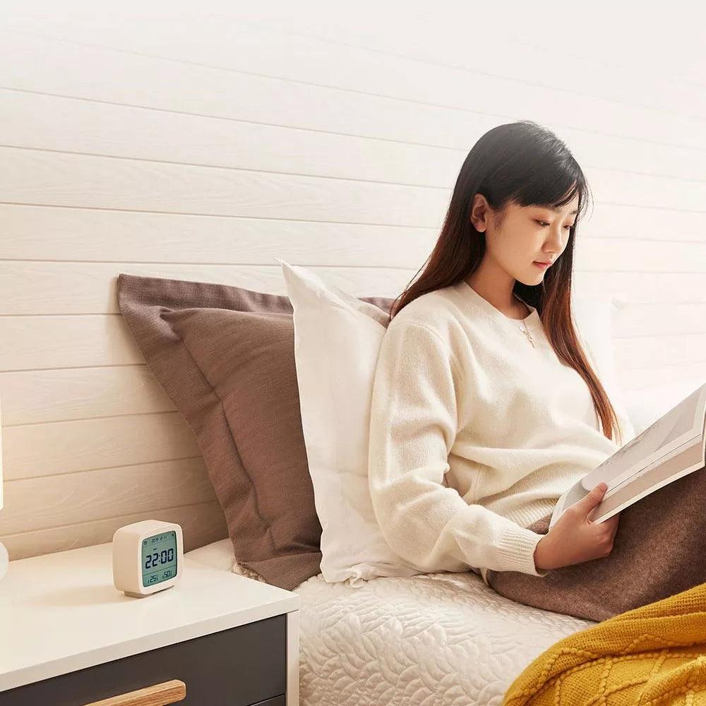 Stevvex Bluetooth alarm clock with LCD display on a nightstand beside a girl reading in bed on Tampa Home & Garden Store