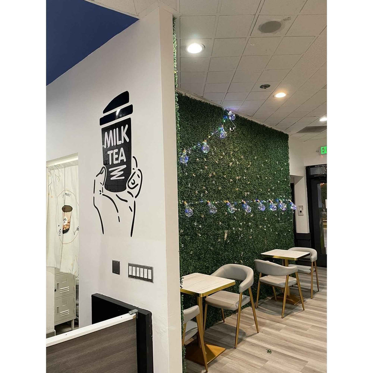 Boba Wall Art Decor acrylic milk tea cup illustration in a cafe with a green hedge wall on Tampa Home & Garden Store
