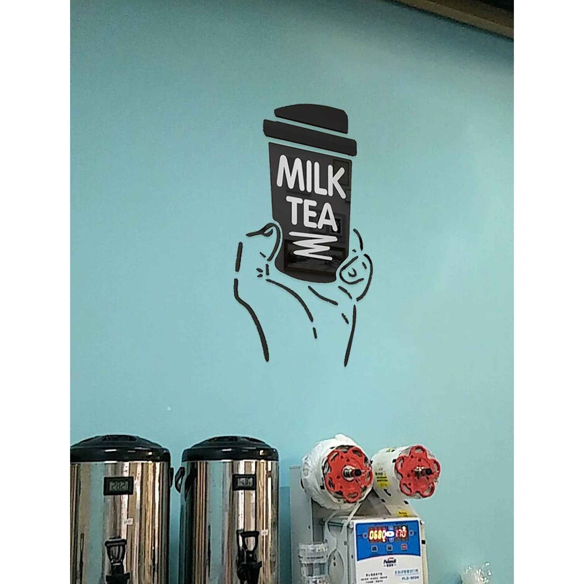 Boba milk tea wall art mural with a hand holding stacked milk tea cup on turquoise cafe wall on Tampa Home & Garden Store