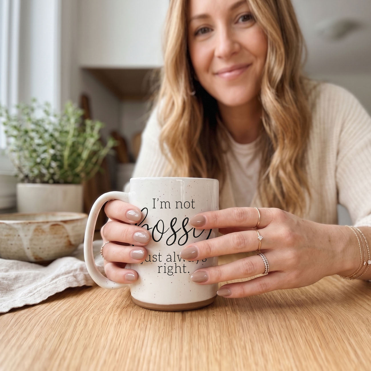Bossy 16oz ceramic coffee mug by Gia Roma speckled white held by a smiling woman on Tampa Home & Garden Store