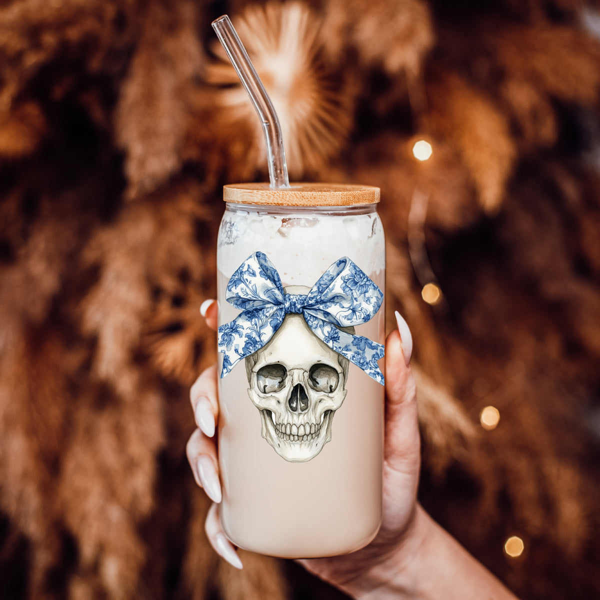 Bow Skull 20oz travel mug with skull graphic and blue floral bow, clear straw, bamboo lid on Tampa Home & Garden Store