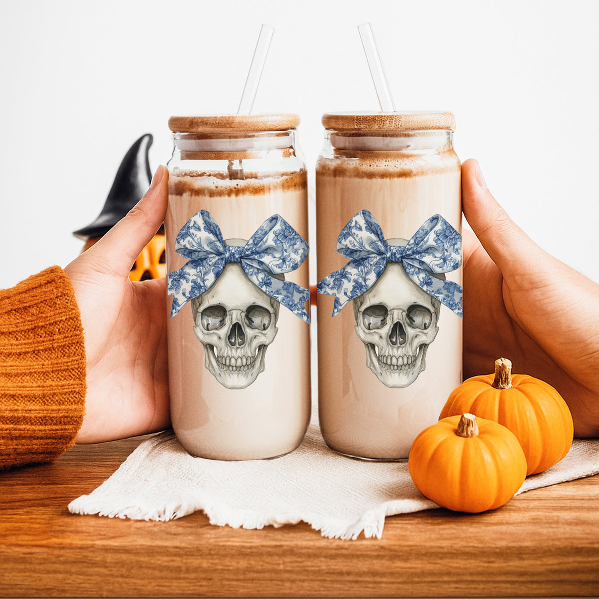 Pair of Bow Skull 20oz travel mugs with cream body, skull graphic and blue bow Gia Roma drinkware on Tampa Home & Garden Store