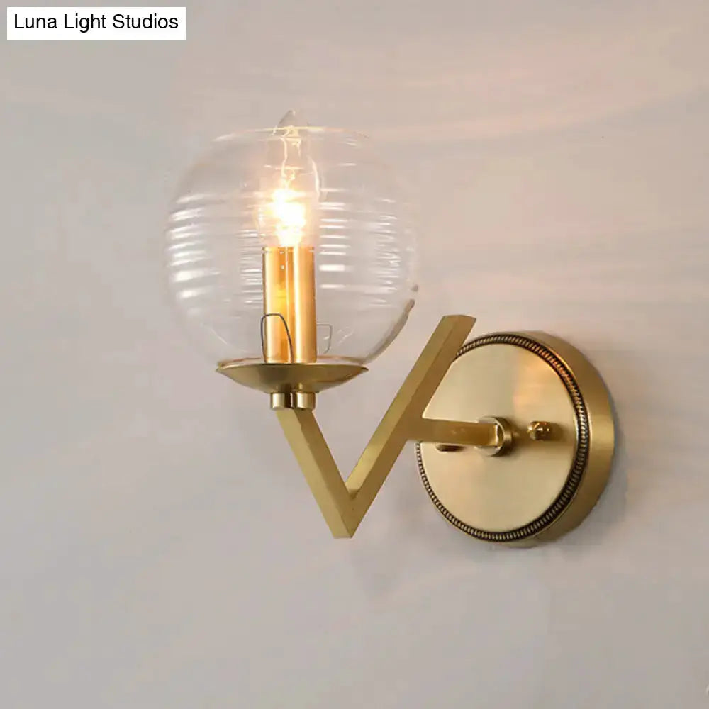 Brass ball sconce with ribbed glass shade and exposed Edison bulb on Tampa Home & Garden Store