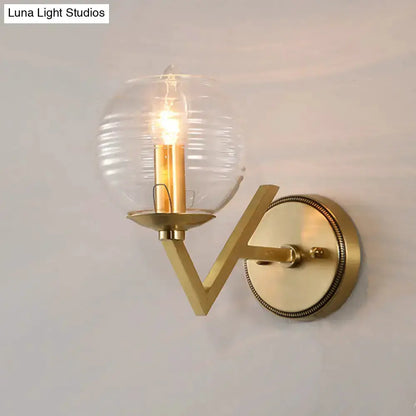 Brass ball sconce with ribbed glass shade and exposed Edison bulb on Tampa Home & Garden Store