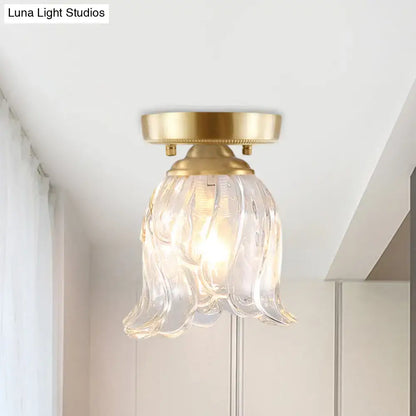 Brass glass flush mount light by Decorbites with flower-shaped clear swirled shade on Tampa Home & Garden Store