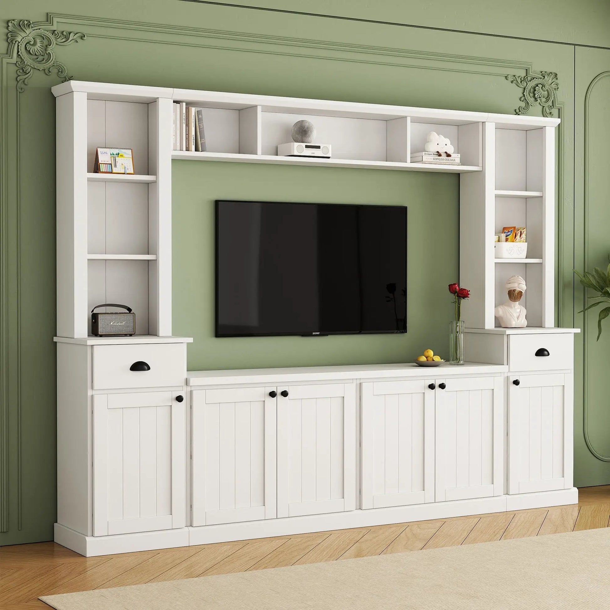 Entertainment wall unit with bridge in white, open shelves around a 75in TV on a green wall on Tampa Home & Garden Store