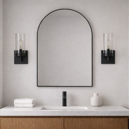 Zephyr two black single-light sconces with clear glass shades flanking an arched mirror on Tampa Home & Garden Store