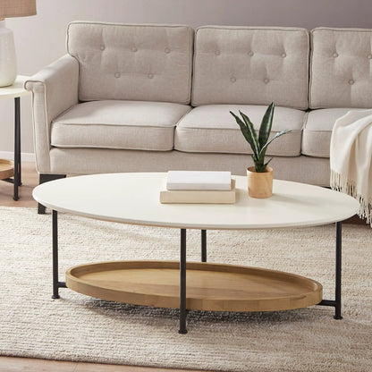 Oval coffee table with white top and natural wood shelf on black metal legs beside beige tufted sofa on Tampa Home & Garden Store