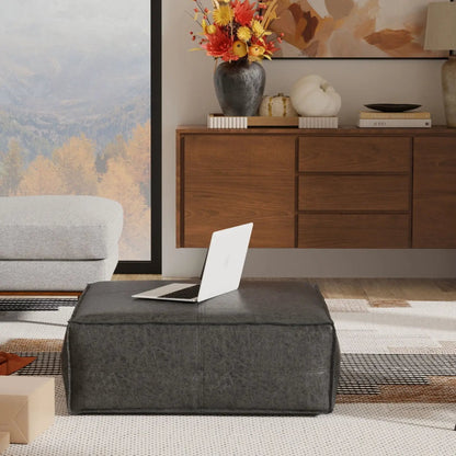 Brody Large Square Coffee Table Pouf charcoal faux leather in living room with laptop on top on Tampa Home & Garden Store
