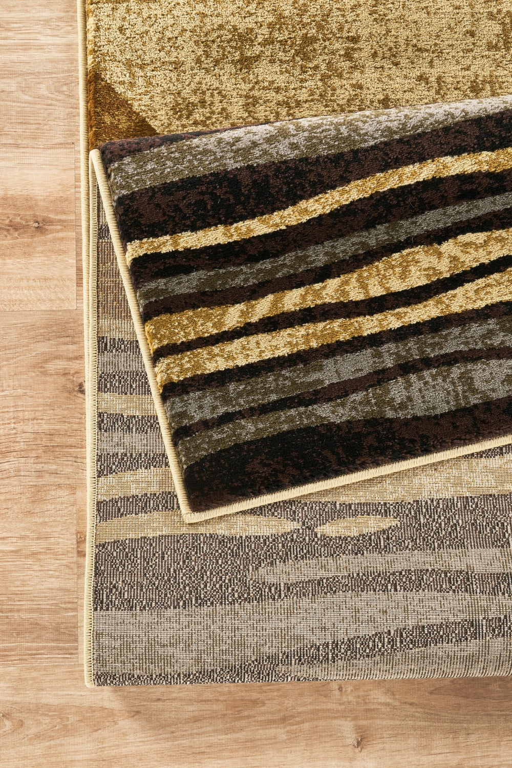 Bristol Modern Geometric Area Rug In Multi, striped brown tan gold palette on wood floor on Tampa Home & Garden Store