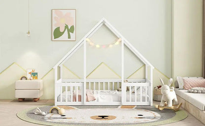 Wood house-shaped floor toddler bed with fence and guardrails in white, set in a pastel nursery on Tampa Home & Garden Store