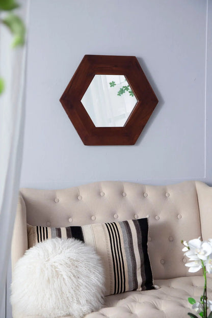 Hexagon mirror with natural wood frame hanging on a light blue wall above a beige tufted sofa on Tampa Home & Garden Store