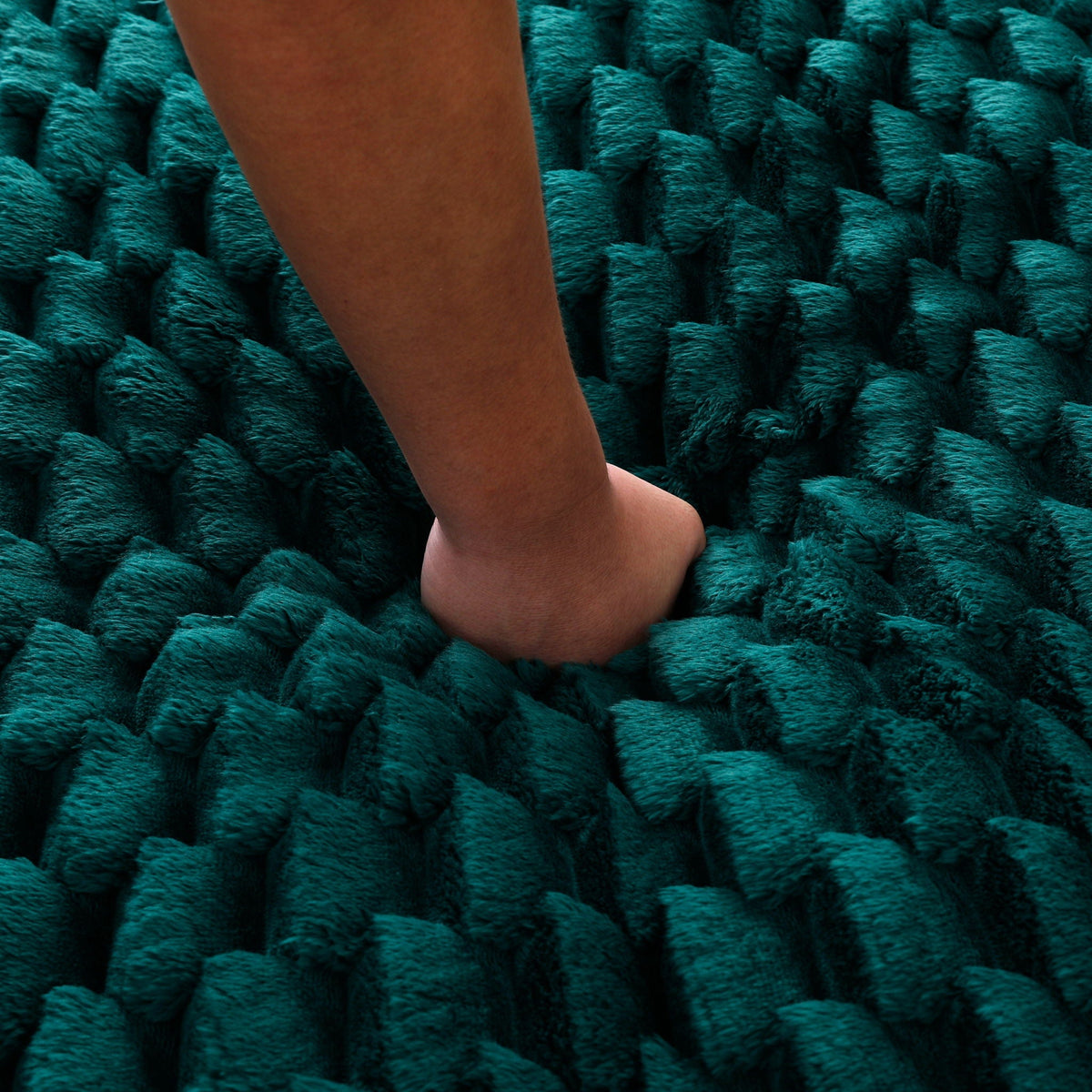 Teal chunky knit rug close-up with a bare leg resting on it on Tampa Home & Garden Store