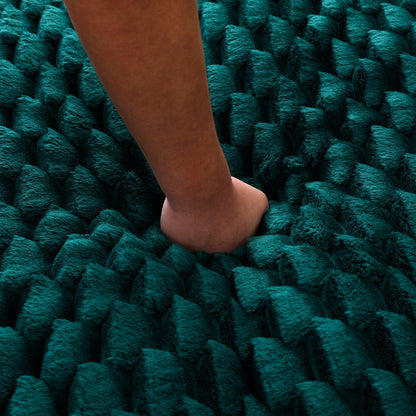 Teal chunky knit rug close-up with a bare leg resting on it on Tampa Home & Garden Store