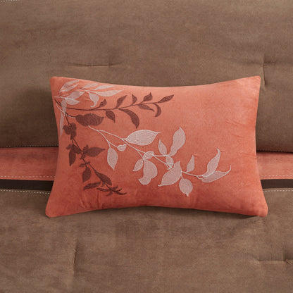 Coral decorative faux suede pillow with white botanical embroidery on brown sofa on Tampa Home & Garden Store