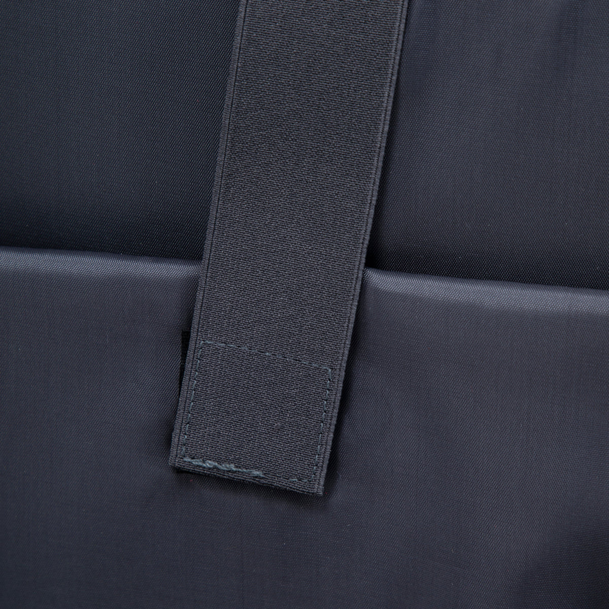 Luggage strap close-up on navy nylon strap against dark fabric background on Tampa Home & Garden Store