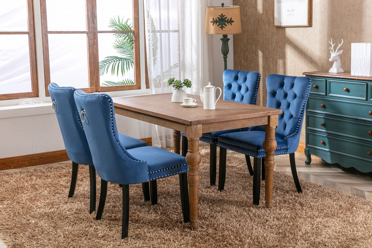 Tufted velvet blue dining chairs with nailhead trim, four chairs around a table on Tampa Home & Garden Store