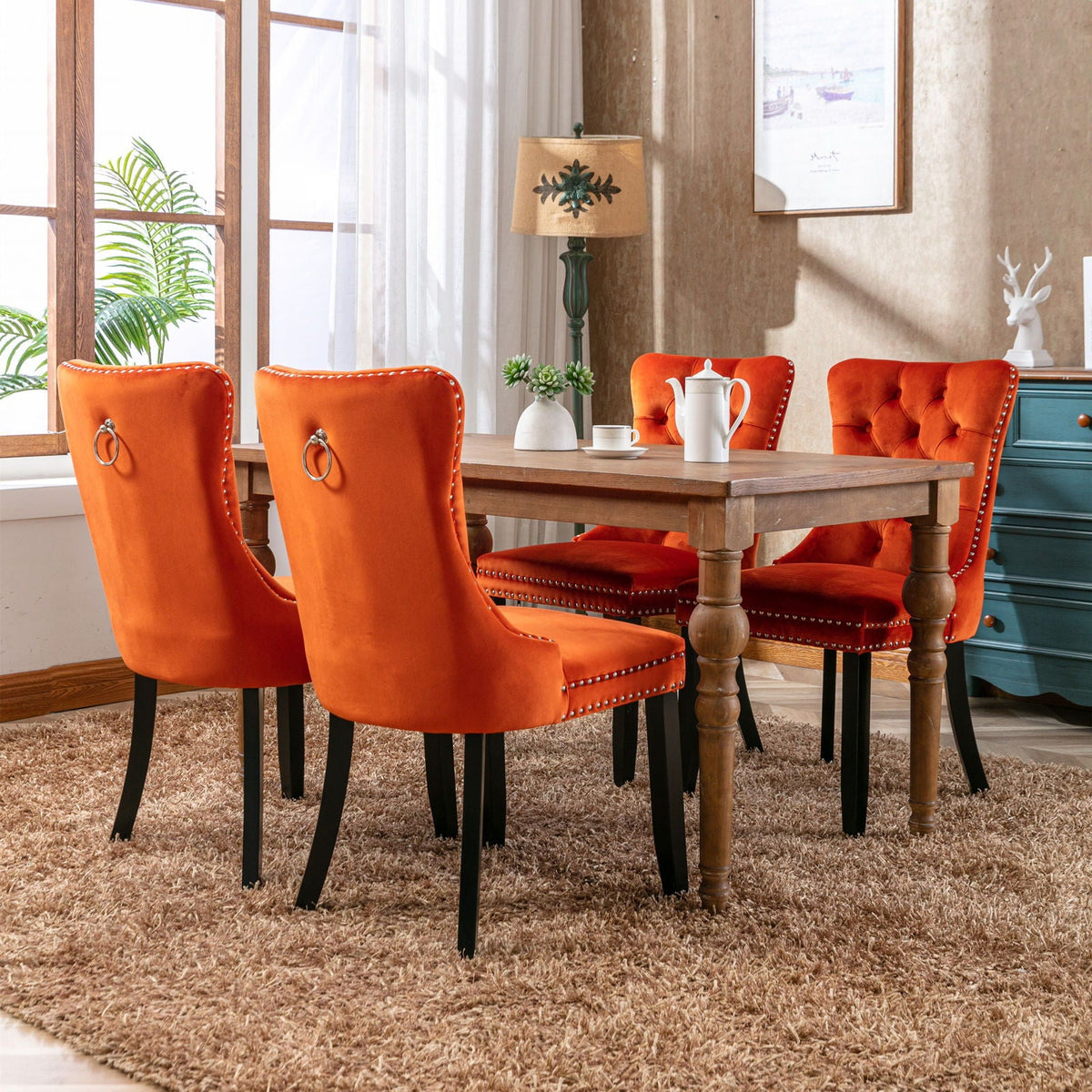 Tufted velvet dining chair set in orange with nailhead trim, 4 chairs around a wooden table on Tampa Home & Garden Store