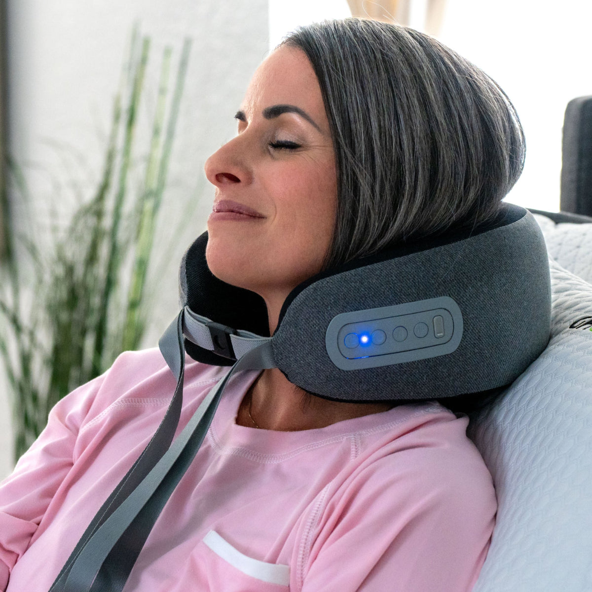 GhostBed neck massage pillow gray worn around neck with built in control panel and blue LED on Tampa Home & Garden Store