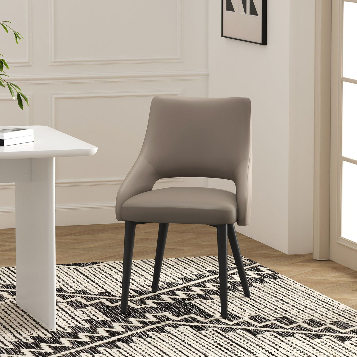 Tremont Dining Chair with Steel Frame in taupe upholstery and black legs in a modern dining nook on Tampa Home & Garden Store